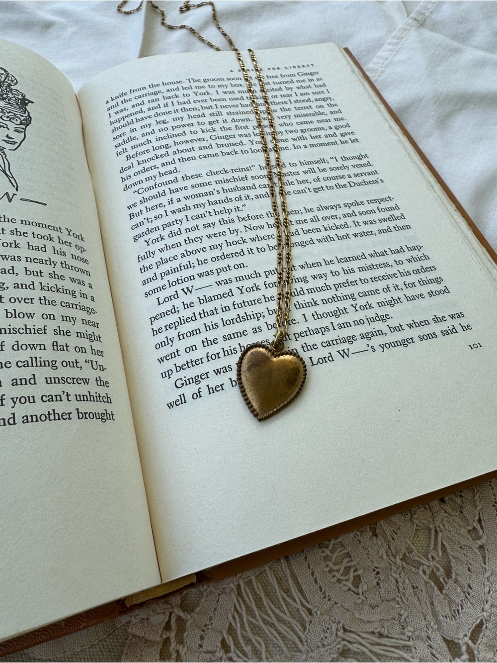 1930s brass heart with patina and beaded trim, on a long gold dipped chain.